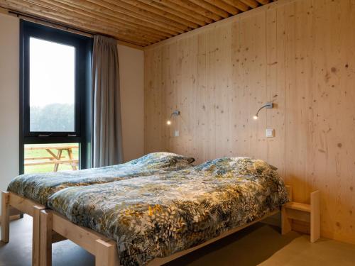 1 dormitorio con 1 cama en una habitación con ventana en Ecological bungalow with decorative fireplace, located on a holiday farm en Heeten