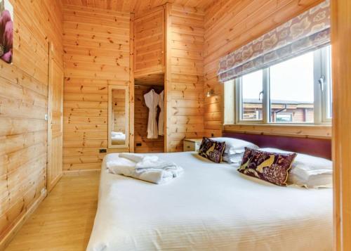 a bedroom with a bed in a wooden room at Fairview Lodges in Withernsea
