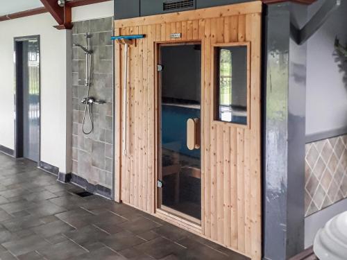 ein Badezimmer mit einer Dusche und Holztüren in der Unterkunft Halls Bank Farm in Aspatria