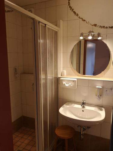 a bathroom with a sink and a mirror and a shower at Hotel Goldflair am Rathaus in Korbach