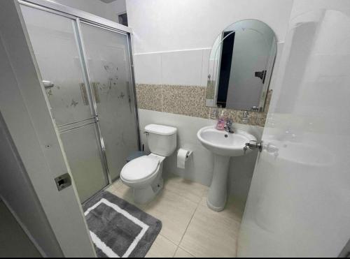 een badkamer met een toilet, een wastafel en een douche bij Joel Arturo Residences in Licey al Medio