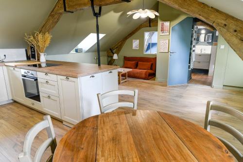 Il comprend une cuisine et une salle à manger avec une table en bois. dans l'établissement Le Petit-Saint-Nicolas, à Troyes