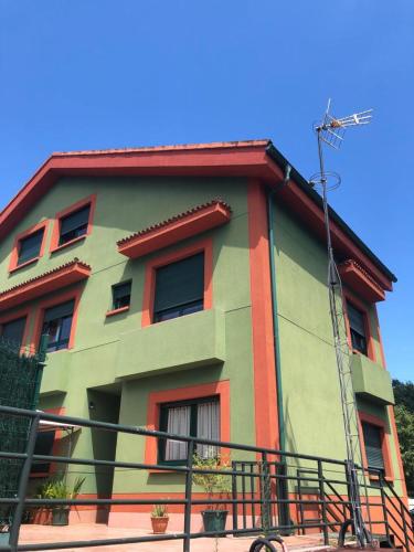 a multicolored building with a fence in front of it at Casa Mariva in Arriondas