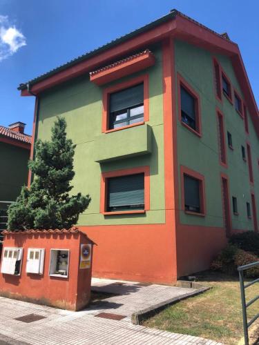 a colorful building with a tree in front of it at Casa Mariva in Arriondas