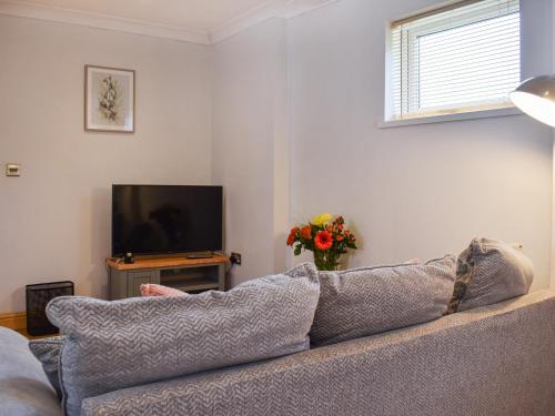 uma sala de estar com um sofá e uma televisão em Roxys Cottage - Uk44687 em Burnopfield