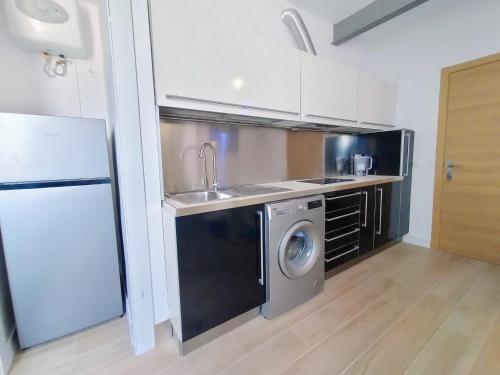 a kitchen with a sink and a washing machine at AGP Globo in Málaga