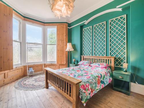a bedroom with a bed and a green wall at Highbury House in Weston-super-Mare