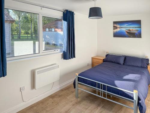 a bedroom with a bed and a window at Owl Lodge in Great Moulton