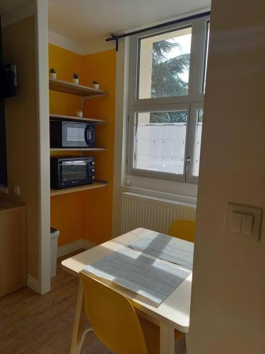 a dining room with a table and a window at La Grelauderie 1 in Saintes