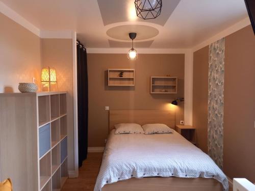 a bedroom with a bed with a white blanket at La Grelauderie 1 in Saintes