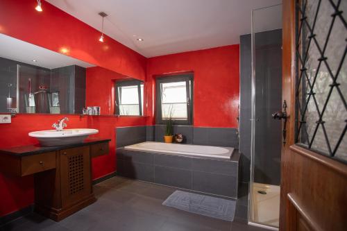 een rode badkamer met een bad en een wastafel bij Chalet Rosenweg in Fügen