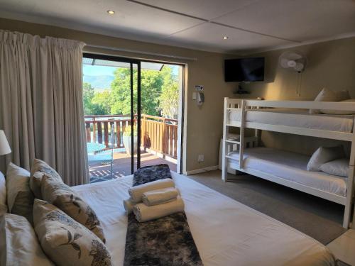 ein Schlafzimmer mit einem Bett und einem Sofa sowie einem Balkon in der Unterkunft Tri-Angle B&B and Guesthouse in Adelaide