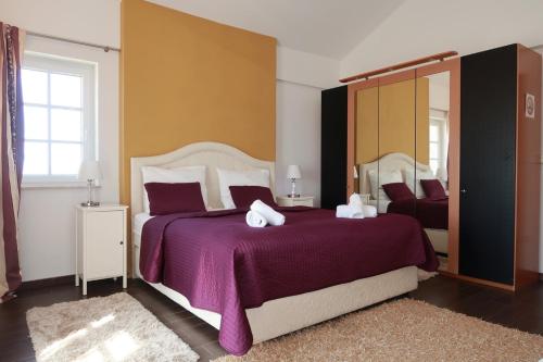 una camera da letto con un letto grande con una coperta viola di Family Villa Blum a Dobrinj