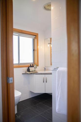 baño con aseo y lavabo y ventana en Keilor airport stay en Albion