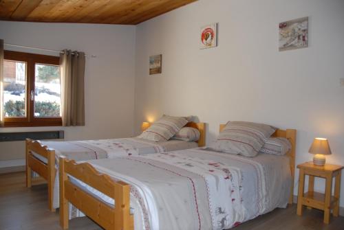2 camas individuales en una habitación con ventana en CHALET LES ECUREUILS, en Barcelonnette