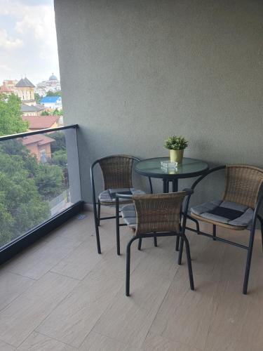 a table and chairs on a balcony with a table and a window at Stadium Central Apartment Residence & terrace in Craiova