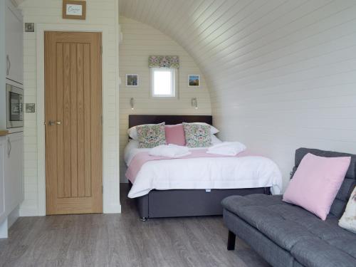 a bedroom with two beds and a couch at Cain Pod Vip in Llanfyllin