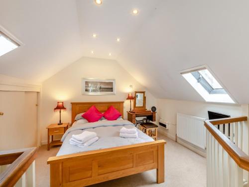 a bedroom with a large bed with red pillows at Littlemoor Barn - Uk44805 in Cloughton