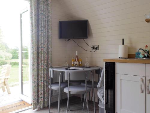 a room with a table and a tv on the wall at Cain Pod Vip in Llanfyllin