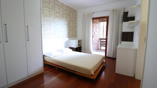 een kleine slaapkamer met een bed en een raam bij Casa da Montanha in Mairiporã