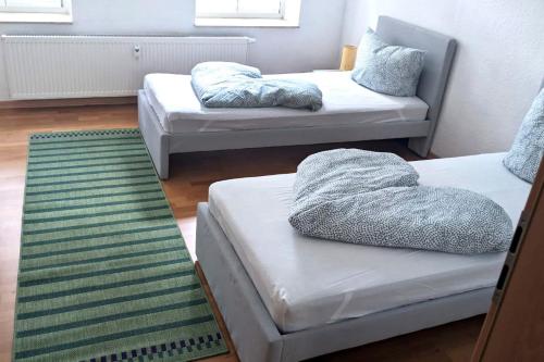 un soggiorno con 2 letti e un tappeto di Nice Apartment with Balcony a Apolda