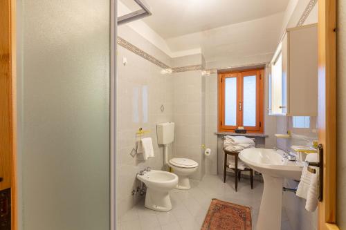 a bathroom with two toilets and a sink and a shower at Maison Bertines II in Casteldelfino