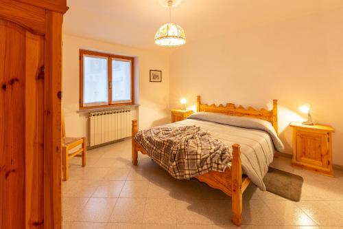 1 dormitorio con cama y ventana en Maison Bertines II, en Casteldelfino