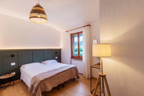 ガルダにあるAppartamenti Le Rasoleのベッドルーム1室(ベッド1台、ランプ、窓付)