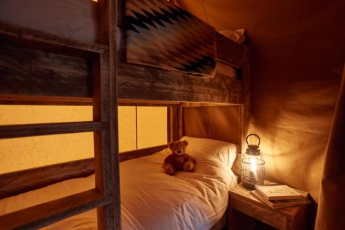 a teddy bear sitting on a bed in a bedroom at The Camp at The Wave in Bristol