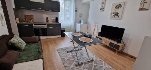 ein Wohnzimmer mit einem Tisch und einer Küche in der Unterkunft Appartement NEUF chaleureux - Comme à la maison in Limoges