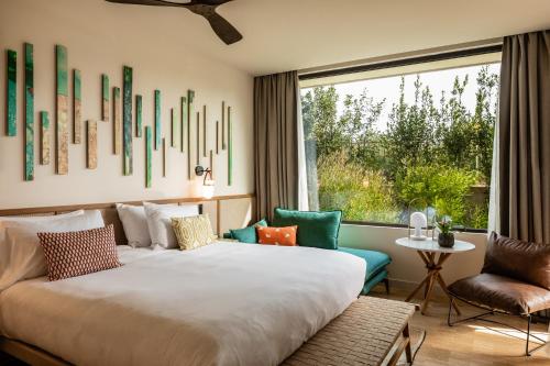a bedroom with a large bed and a window at Kimpton Aysla Mallorca by IHG in Santa Ponsa