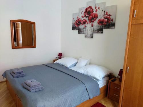a bedroom with a bed with two towels on it at Little Hungary Apartment in Budapest