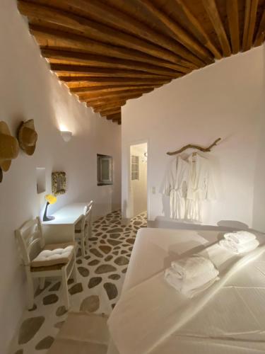 1 dormitorio con cama, escritorio y mesa en Cybele guesthouse, en Chrousa