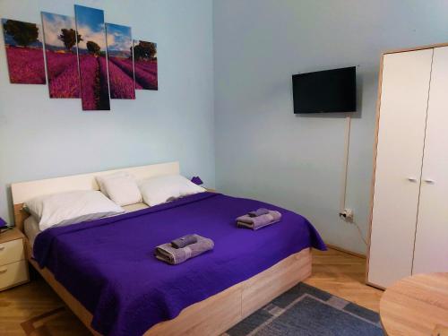 a bedroom with a bed with two towels on it at Little Hungary Apartment in Budapest
