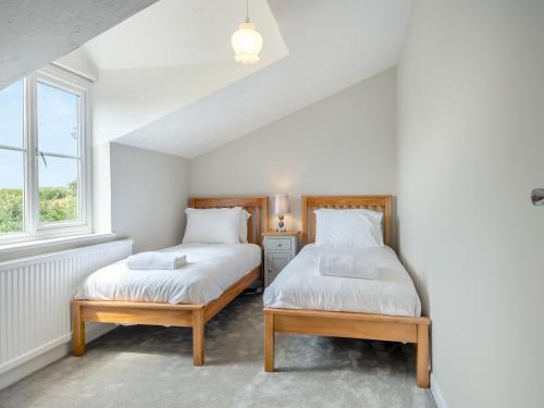a bedroom with two beds and a window at Baythorn End in Antingham