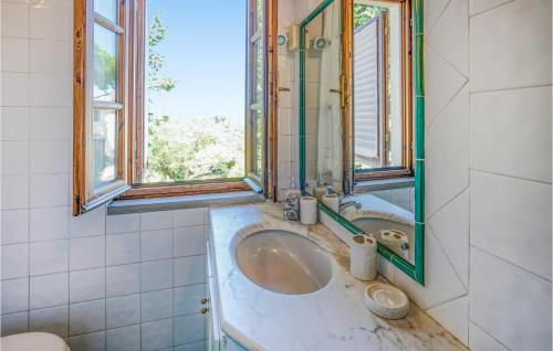 een badkamer met een wastafel en 2 ramen bij Cozy Home In Montespertoli With Outdoor Swimming Pool in Montespertoli