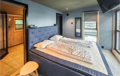 um quarto com uma cama grande e uma parede azul em Awesome Home In Brevik With Indoor Swimming Pool, Private Swimming Pool And 5 Bedrooms em Brevik