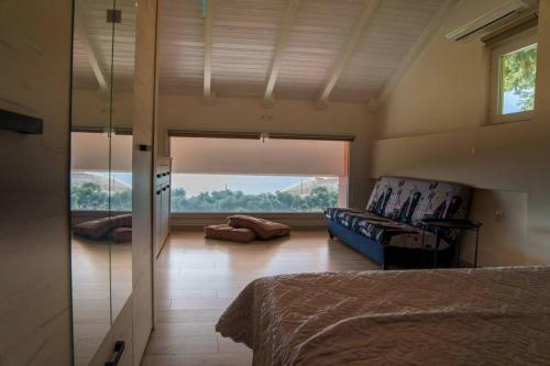Cette chambre comprend un lit, un canapé et une fenêtre. dans l'établissement Mannou House, à Paralia Vrachou