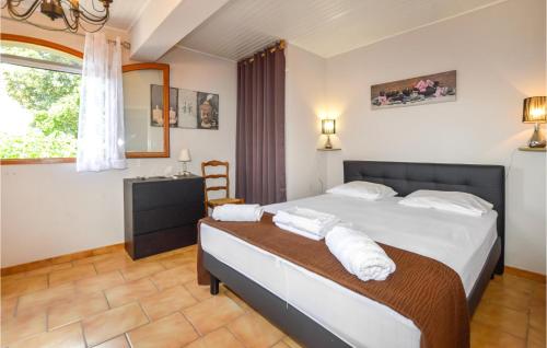 a bedroom with a bed and a chair and a window at Amazing Home In Giuncaggo With Wifi in Aléria