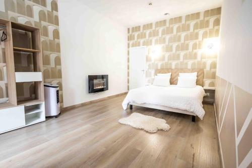 a white bedroom with a bed and a fireplace at Hôtel Center Saint-Quentin Centre Gare in Saint-Quentin