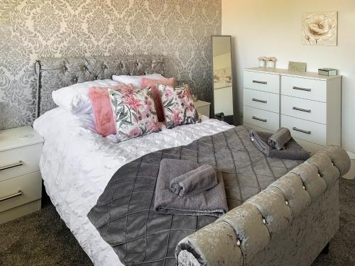 1 dormitorio con 1 cama con almohadas y vestidor en Sunny Prestatyn Apartment en Prestatyn