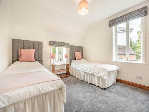 dwa łóżka w pokoju z dwoma oknami w obiekcie The Granary w mieście Tetford