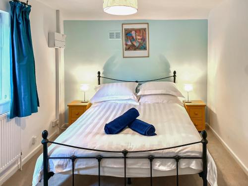 Un dormitorio con una cama con dos calcetines azules. en Garden Cottage 2 - Uk42882, en Liphook