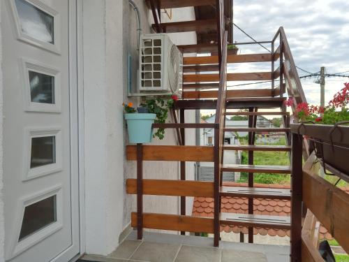 a stairway with a plant in a pot next to a door at Apartman kod dide i bake in Vukovar