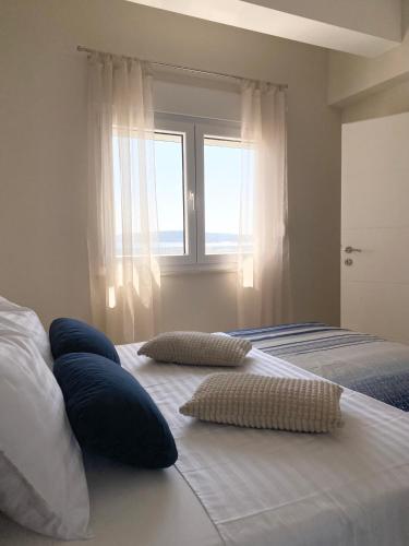 two pillows on a bed in a bedroom with a window at Apartment Azuri in Okrug Donji