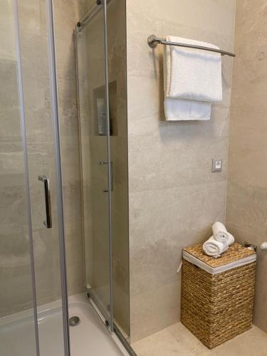 a shower stall in a bathroom with a basket and towels at Apartment Azuri in Okrug Donji