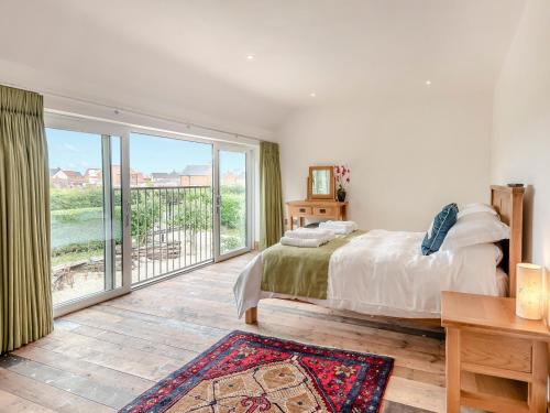 um quarto com uma cama e uma grande janela em Herons Den - Uk44529 em Horncastle