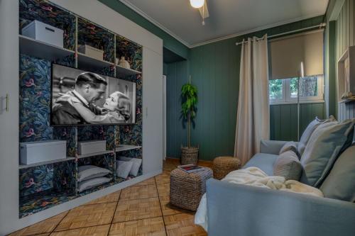a living room with a couch and a tv on a wall at The Southern Mansion Athens in Athens
