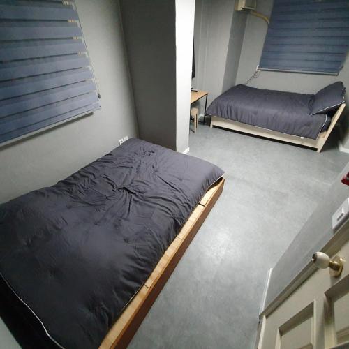 a bedroom with two beds and a window at Seven Hostel in Seoul