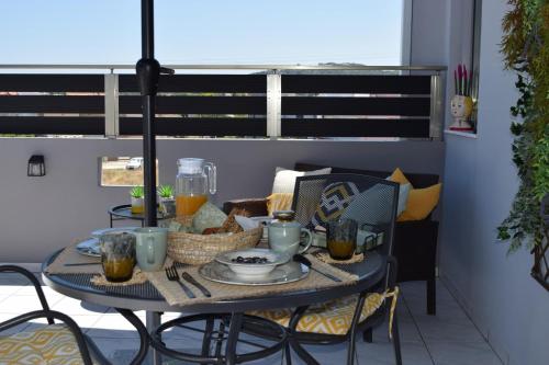a table with food and drinks on a balcony at Stamatina's Luxury Penthouse in Pastida in Pastida